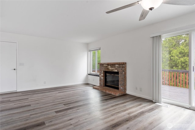 1258 NW Timber Shadow Ct, Silverdale, WA 98380 - unfurnished living room featuring wood finished floors, a ceiling fan, a fireplace, and baseboards