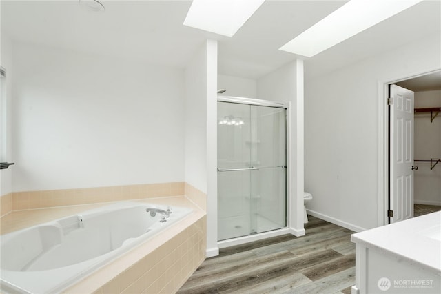 1258 NW Timber Shadow Ct, Silverdale, WA 98380 - full bathroom featuring toilet, a skylight, a bath, a shower stall, and wood finished floors