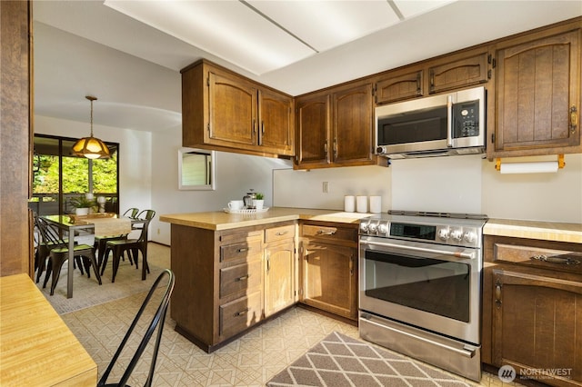 18801 86th Pl W, Edmonds, WA 98026 - kitchen with stainless steel appliances, light countertops, a peninsula, and decorative light fixtures