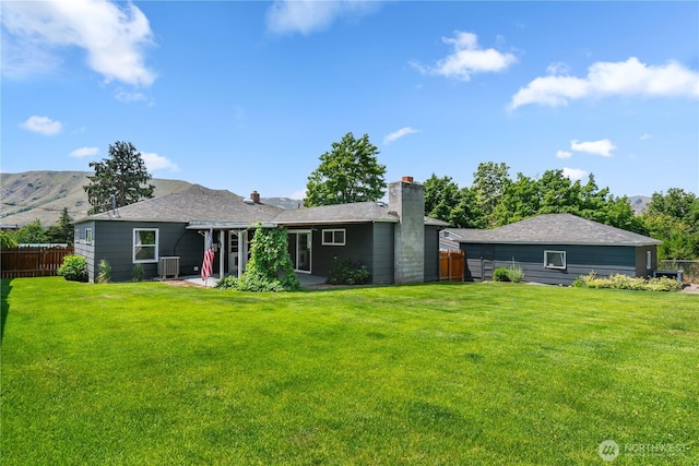 367 1st St SE, East Wenatchee, WA 98802 - back of property with central AC unit, a chimney, and a mountain view