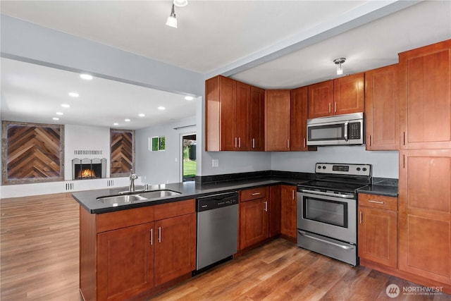 367 1st St SE, East Wenatchee, WA 98802 - kitchen featuring appliances with stainless steel finishes, a sink, dark countertops, a peninsula, and light wood-style flooring