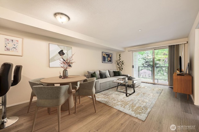 3022 SW Bradford St Unit 205, Seattle, WA 98126 - living room with wood finished floors, baseboards, and a textured ceiling