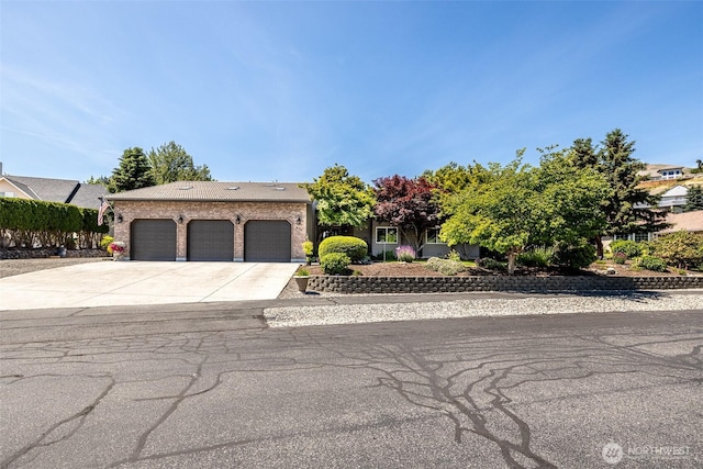 628 Meadows Dr, Wenatchee, WA 98801 - obstructed view of property featuring an attached garage and concrete driveway