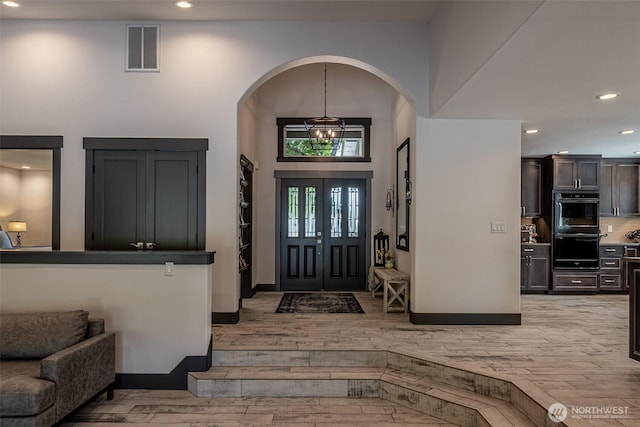 628 Meadows Dr, Wenatchee, WA 98801 - foyer entrance featuring light wood-type flooring, recessed lighting, arched walkways, a towering ceiling, and baseboards