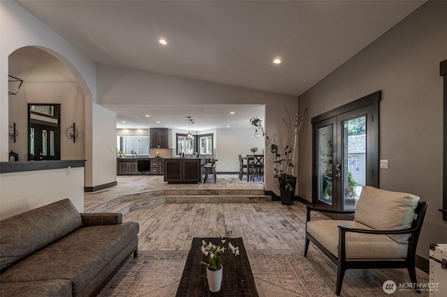 628 Meadows Dr, Wenatchee, WA 98801 - living room with recessed lighting, lofted ceiling, baseboards, light wood finished floors, and arched walkways