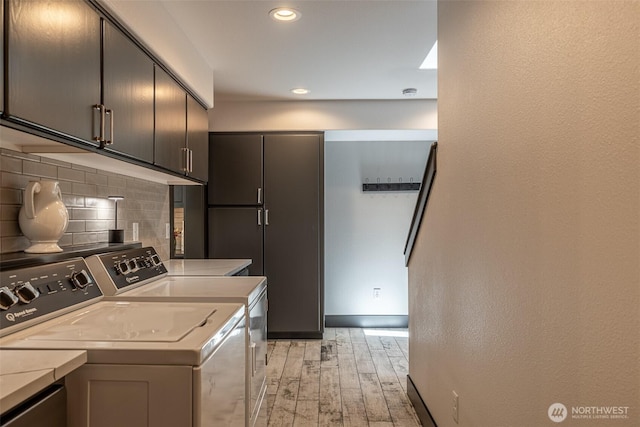 628 Meadows Dr, Wenatchee, WA 98801 - laundry area featuring cabinet space, light wood finished floors, washer and clothes dryer, recessed lighting, and baseboards
