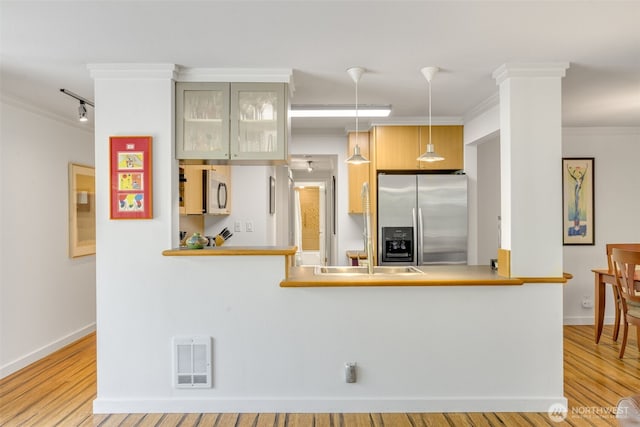 732 11th Ave E Unit 202, Seattle, WA 98102 - kitchen with appliances with stainless steel finishes, a sink, wood finished floors, crown molding, and pendant lighting