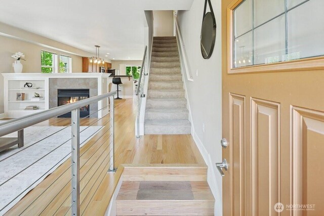 7121 Shinkle Pl SW, Seattle, WA 98106 - entryway featuring a tile fireplace, wood finished floors, baseboards, and stairs