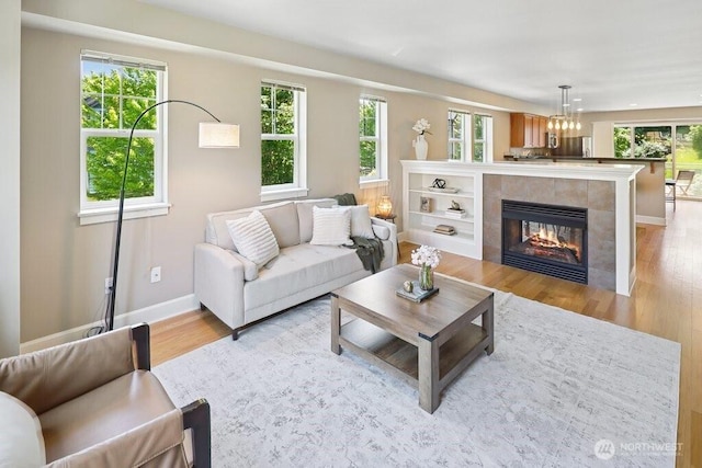 7121 Shinkle Pl SW, Seattle, WA 98106 - living room with light wood-style flooring, a tiled fireplace, plenty of natural light, and baseboards