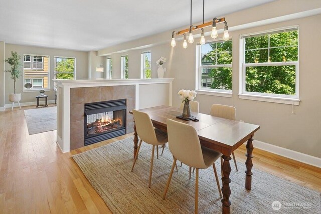 7121 Shinkle Pl SW, Seattle, WA 98106 - dining area with baseboards, a fireplace, and light wood-style floors