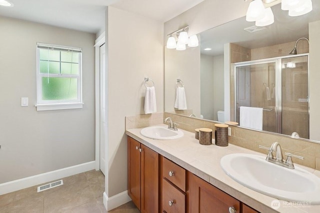 7121 Shinkle Pl SW, Seattle, WA 98106 - bathroom featuring a stall shower, double vanity, tile patterned floors, toilet, and baseboards