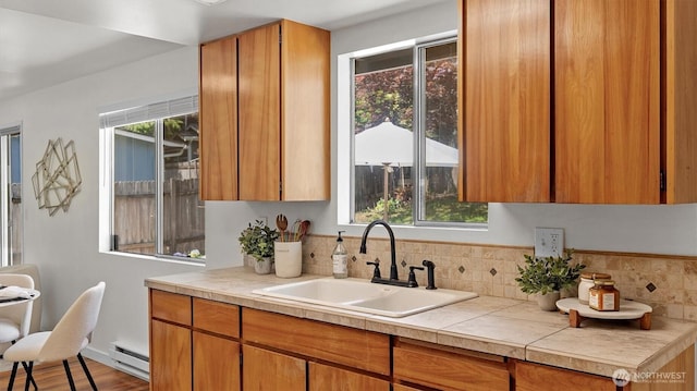 19932 NE 175th St, Woodinville, WA 98077 - kitchen featuring brown cabinetry, decorative backsplash, a baseboard radiator, and wood finished floors