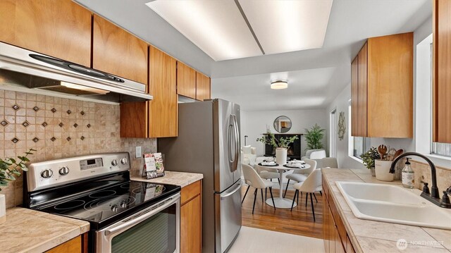 19932 NE 175th St, Woodinville, WA 98077 - kitchen featuring stainless steel appliances, tasteful backsplash, range hood, and brown cabinets