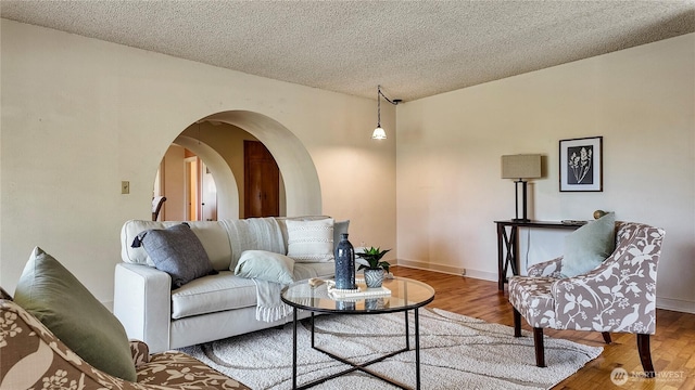 2502 Thurston Ave NE, Olympia, WA 98506 - living room featuring arched walkways, wood finished floors, a textured ceiling, and baseboards