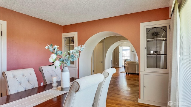 2502 Thurston Ave NE, Olympia, WA 98506 - dining space with arched walkways, wood finished floors, and a textured ceiling