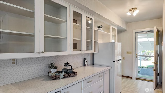 2502 Thurston Ave NE, Olympia, WA 98506 - kitchen with freestanding refrigerator, light countertops, white cabinetry, and glass insert cabinets