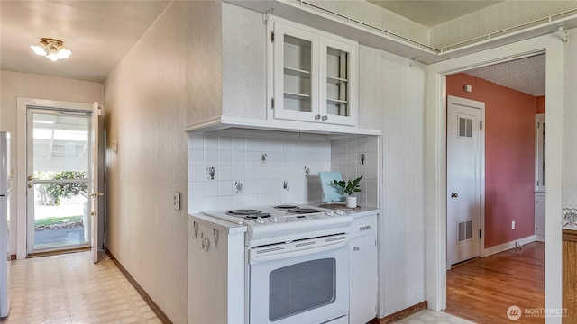 2502 Thurston Ave NE, Olympia, WA 98506 - kitchen with white range with electric cooktop, light countertops, white cabinets, tasteful backsplash, and baseboards