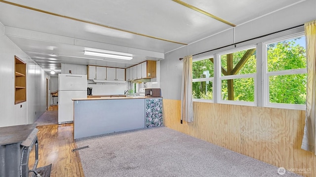 13010 168th St NE, Arlington, WA 98223 - kitchen with freestanding refrigerator, wood walls, and a peninsula