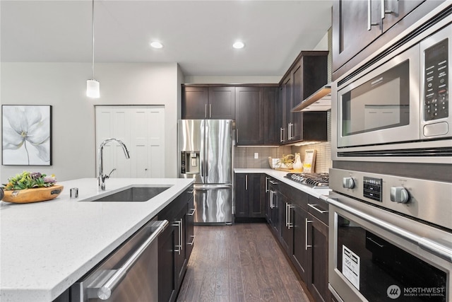 4008 223rd Pl SE, Bothell, WA 98021 - kitchen with appliances with stainless steel finishes, dark brown cabinetry, dark wood finished floors, tasteful backsplash, and light stone countertops