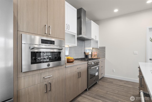 4576 22nd Ave SW, Seattle, WA 98106 - kitchen with appliances with stainless steel finishes, wall chimney range hood, light countertops, dark wood-style floors, and decorative backsplash
