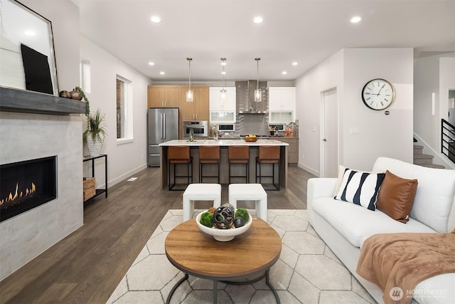 4576 22nd Ave SW, Seattle, WA 98106 - living room with light wood finished floors, recessed lighting, a lit fireplace, and stairway