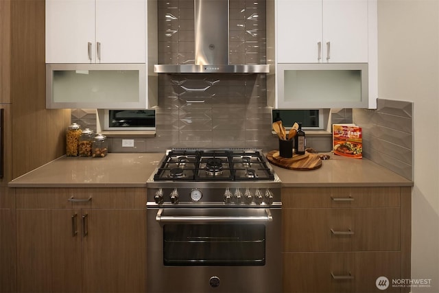 4576 22nd Ave SW, Seattle, WA 98106 - kitchen with high end stainless steel range, wall chimney range hood, white cabinetry, and decorative backsplash