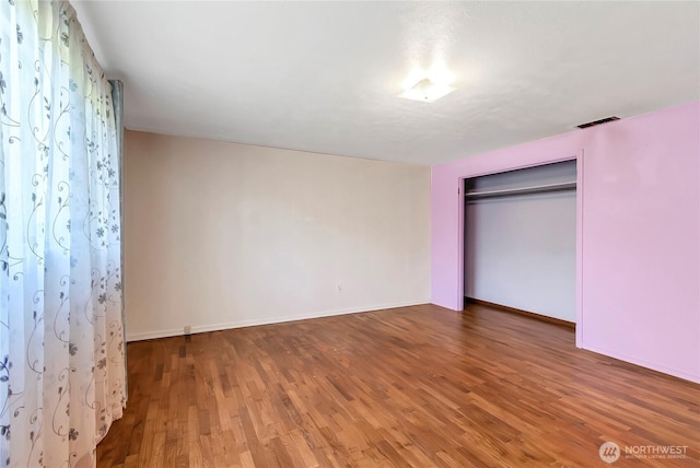 220 Alder Ave, Sumner, WA 98390 - unfurnished bedroom featuring wood finished floors, baseboards, and a closet