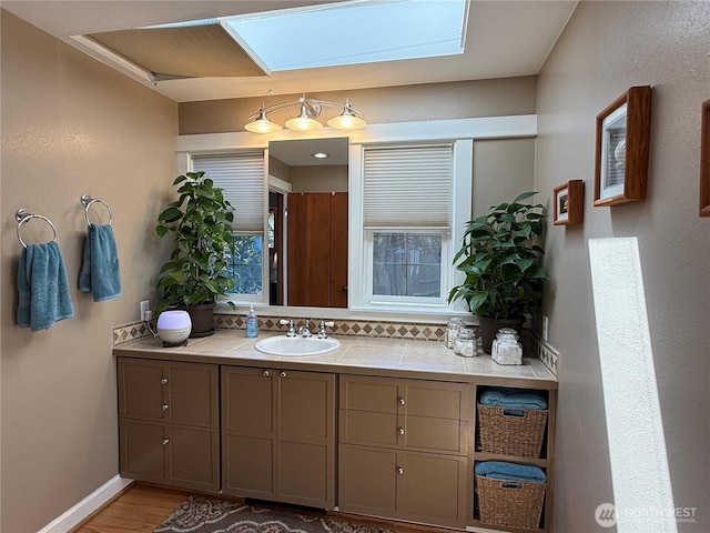 115 15th St SW, Long Beach, WA 98631 - bathroom with vanity, a skylight, wood finished floors, and baseboards