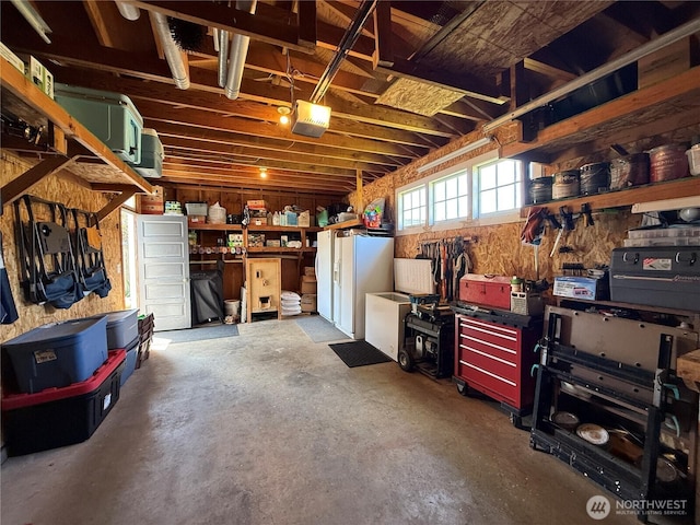 115 15th St SW, Long Beach, WA 98631 - garage with a workshop area, a garage door opener, and white fridge with ice dispenser