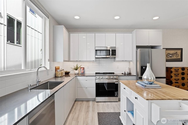 2527 29th Ave S Unit A, Seattle, WA 98144 - kitchen featuring stainless steel appliances, a sink, white cabinets, and recessed lighting