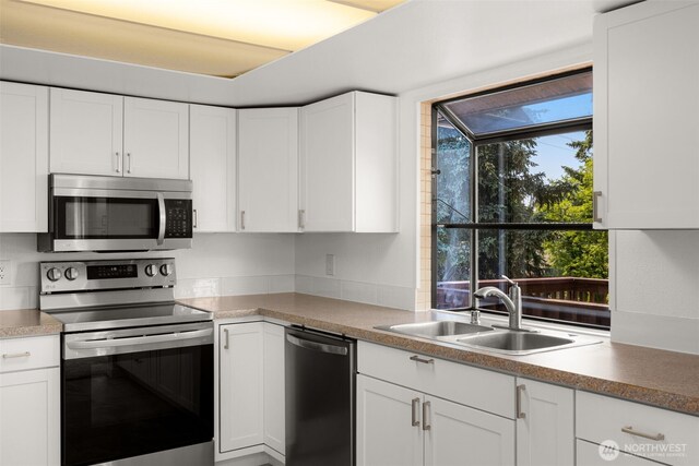 17122 40th Ave W, Lynnwood, WA 98037 - kitchen featuring stainless steel appliances, a sink, white cabinets, and light countertops
