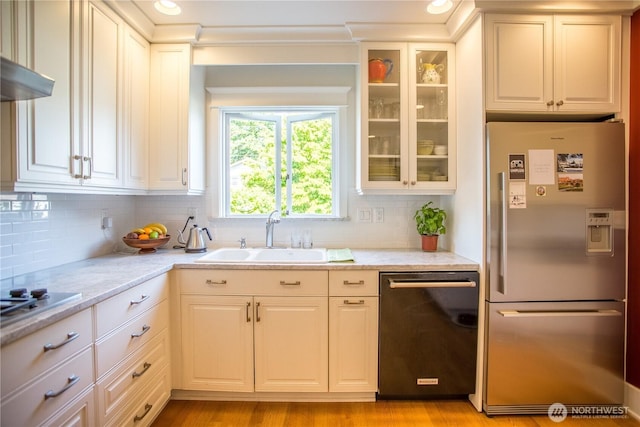 1510 Water St SW, Olympia, WA 98501 - kitchen featuring appliances with stainless steel finishes, a sink, glass insert cabinets, and decorative backsplash