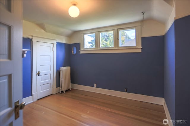 1510 Water St SW, Olympia, WA 98501 - unfurnished bedroom featuring radiator, wood finished floors, lofted ceiling, and baseboards
