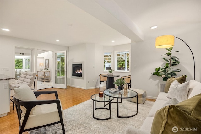11710 Arrow Point Dr NE, Bainbridge Island, WA 98110 - living area with light wood finished floors, healthy amount of natural light, a warm lit fireplace, recessed lighting, and baseboards