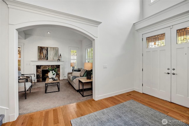 1122 140th Ave SE, Bellevue, WA 98005 - foyer entrance featuring arched walkways, light wood-type flooring, a fireplace, and baseboards