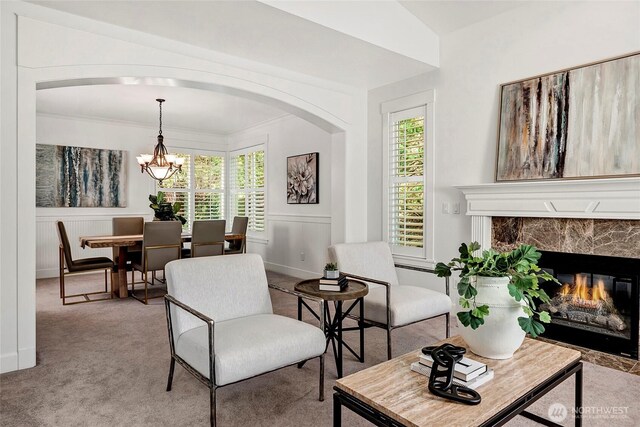 1122 140th Ave SE, Bellevue, WA 98005 - living room featuring a chandelier, arched walkways, light carpet, healthy amount of natural light, and ornamental molding