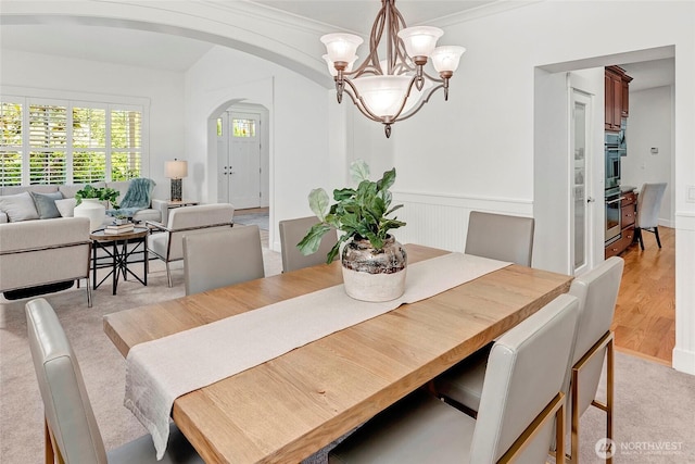 1122 140th Ave SE, Bellevue, WA 98005 - dining room featuring arched walkways, a chandelier, wainscoting, and ornamental molding