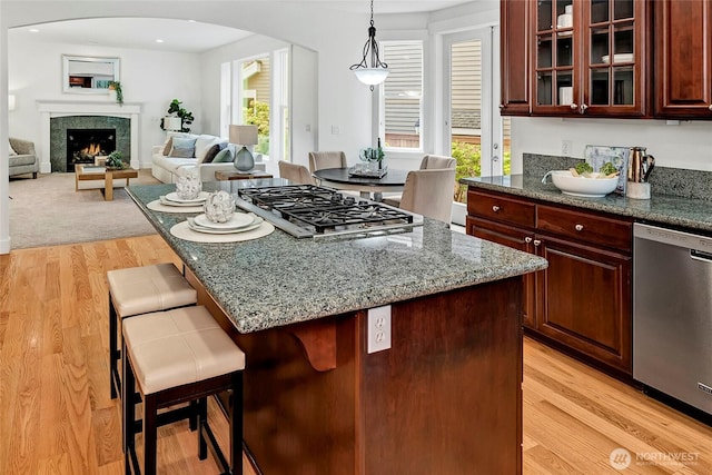 1122 140th Ave SE, Bellevue, WA 98005 - kitchen with stainless steel appliances, arched walkways, a breakfast bar, and light wood finished floors