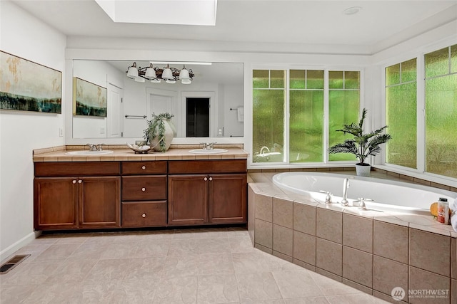 1122 140th Ave SE, Bellevue, WA 98005 - bathroom with a skylight, double vanity, a bath, and tile patterned floors