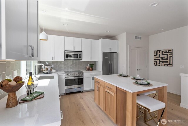 4521A Bagley Ave N, Seattle, WA 98103 - kitchen featuring stainless steel appliances, light countertops, light wood-style flooring, and recessed lighting