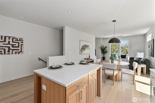 4521A Bagley Ave N, Seattle, WA 98103 - kitchen with light wood finished floors, light countertops, a center island, pendant lighting, and recessed lighting