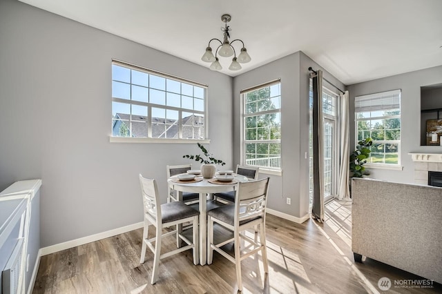 1855 Trossachs Blvd SE Unit 1404, Sammamish, WA 98075 - dining room featuring a chandelier, wood finished floors, baseboards, and a tiled fireplace