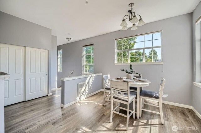 1855 Trossachs Blvd SE Unit 1404, Sammamish, WA 98075 - dining room featuring a chandelier, baseboards, and light wood-style flooring