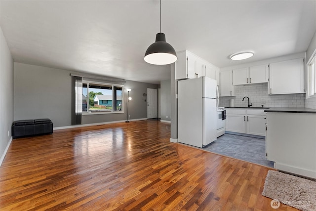 1115 S Evergreen Dr, Moses Lake, WA 98837 - kitchen featuring white appliances, open floor plan, dark countertops, and wood finished floors