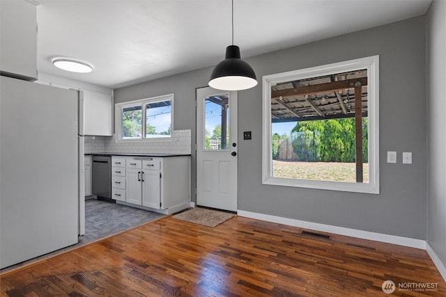 1115 S Evergreen Dr, Moses Lake, WA 98837 - kitchen featuring freestanding refrigerator, stainless steel dishwasher, dark countertops, white cabinetry, and tasteful backsplash