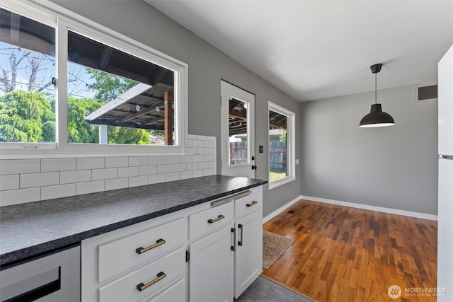 1115 S Evergreen Dr, Moses Lake, WA 98837 - kitchen featuring dark countertops, tasteful backsplash, baseboards, white cabinetry, and dark wood-style floors