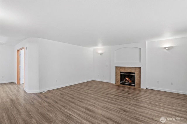 13924 Dogwood Ct, Sultan, WA 98294 - unfurnished living room with wood finished floors, a tiled fireplace, and baseboards