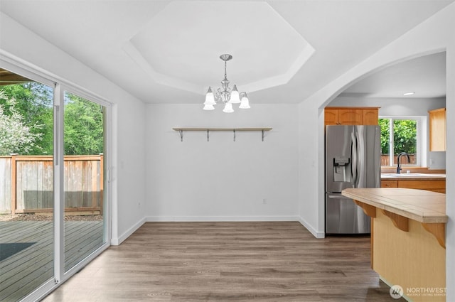 13924 Dogwood Ct, Sultan, WA 98294 - dining area featuring dark wood finished floors, a raised ceiling, a chandelier, and arched walkways
