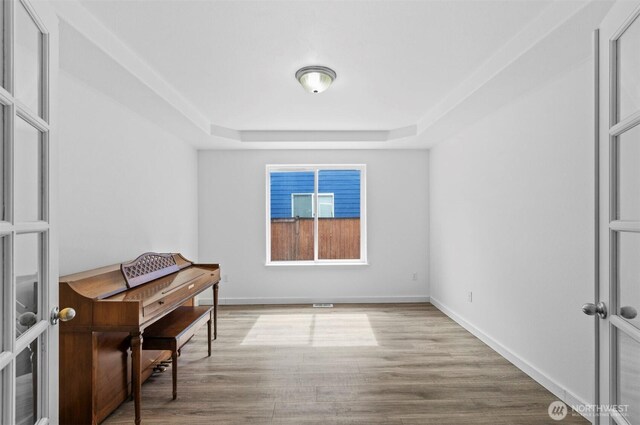 13924 Dogwood Ct, Sultan, WA 98294 - empty room featuring a tray ceiling, wood finished floors, and baseboards