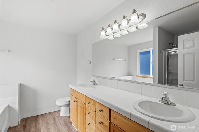 13924 Dogwood Ct, Sultan, WA 98294 - full bath with a garden tub, double vanity, a stall shower, and wood finished floors